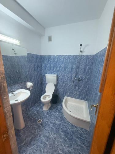 a bathroom with a toilet and a sink and a tub at Vila njoy by the sea in Eforie Sud