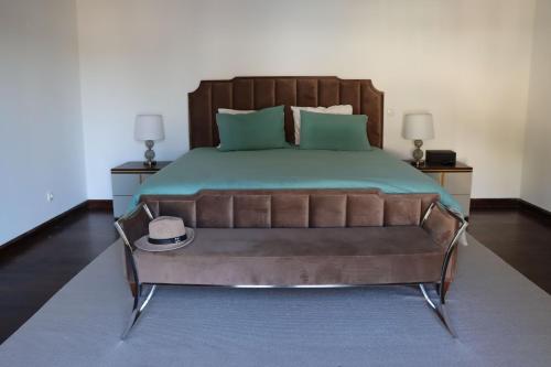 a bedroom with a bed with a hat on it at Herdade Paraíso da Moçarria in Santarém