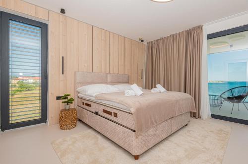 a bedroom with a bed with a view of the ocean at Seafront Villa Serena with pool and seaview in Privlaka