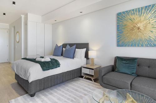 a bedroom with a bed and a couch at Ellipse Waterfall 3802 in Midrand