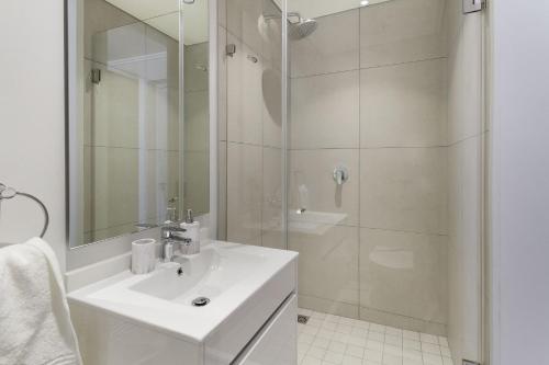 a white bathroom with a sink and a shower at Ellipse Waterfall 3802 in Midrand