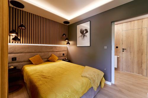 a bedroom with a yellow bed in a room at LAGUNA Apartament Polanica Residence 14 SPA z tarasem in Polanica-Zdrój