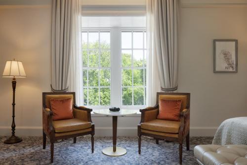 a living room with two chairs and a table and a window at The Caledonian Edinburgh, Curio Collection by Hilton in Edinburgh