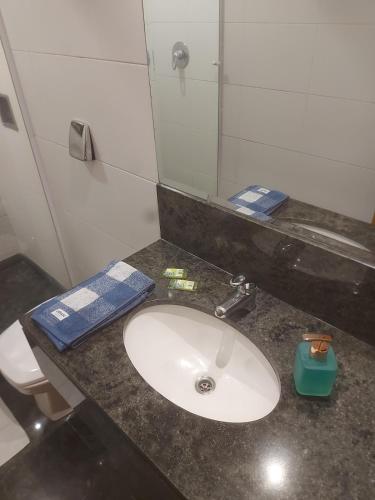 a bathroom with a sink with a mirror and a toilet at Studio ao lado do Museu do Amanhã in Rio de Janeiro