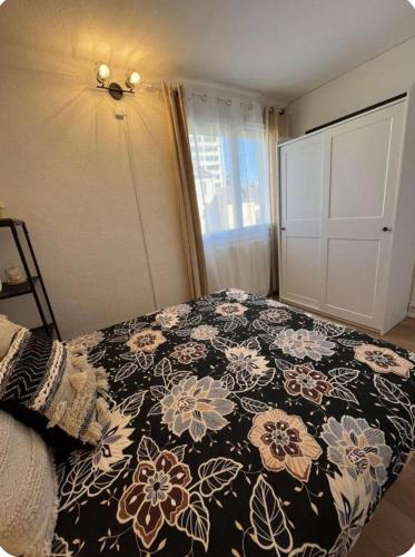 a bedroom with a bed with a black and white blanket at L'escale au centre de Valence in Valence