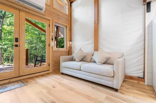 a living room with a white couch and a sliding glass door at Tree Farm Duo - Best of the Ozarks in Walnut Shade