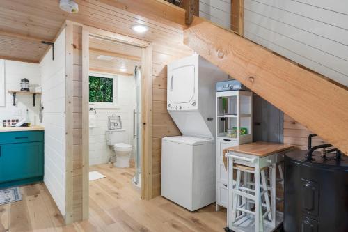 a kitchen with a refrigerator and a toilet in a tiny house at Tree Farm Duo - Best of the Ozarks in Walnut Shade