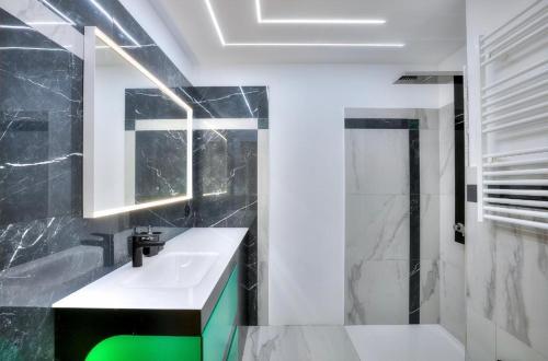 a black and white bathroom with a sink and a shower at Sea View 1B Apartment, Théoule in Théoule-sur-Mer