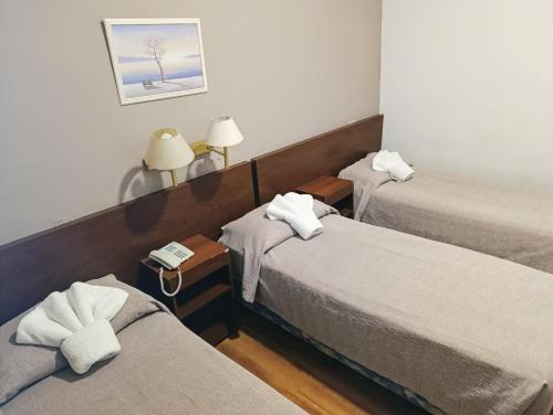 a hotel room with two beds with towels at Hotel Milan in Buenos Aires