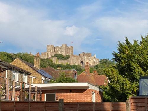 a castle on top of a hill with houses at Two Dover Ferry Apartments - sleep 8 with private terrace and castle views in Kent