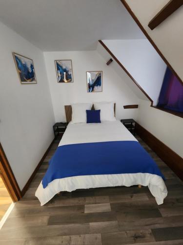 a bedroom with a blue and white bed at chambre mauve in Saint-Nicolas-dʼAliermont