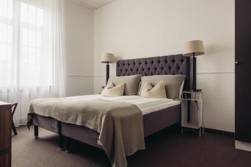 a bedroom with a large bed with white sheets and pillows at Varbergs Kusthotell in Varberg