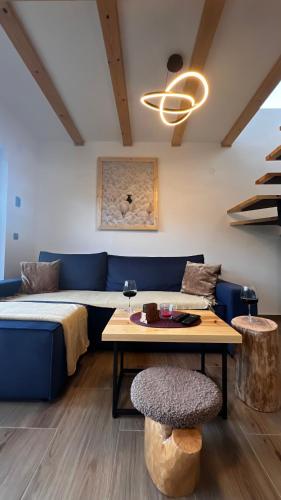 a living room with a blue couch and a table at Planinska koliba Dada in Popovići