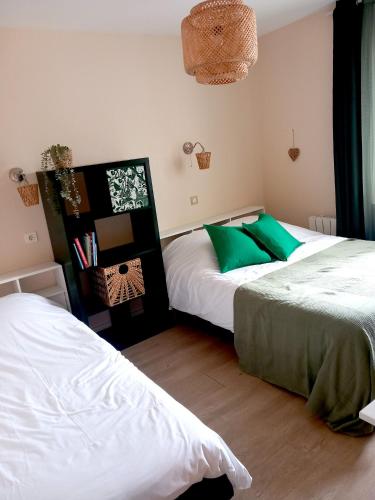 two beds in a room with green and white at Les copains d'amour in Guérande