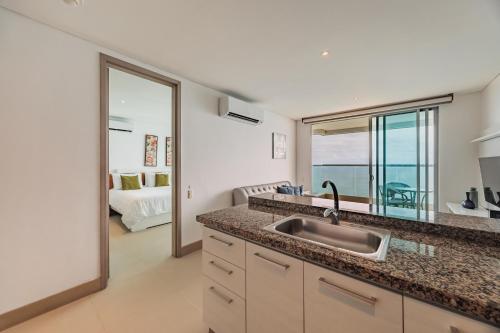 een keuken met een spoelbak en uitzicht op de oceaan bij Palmetto Beach by MOME in Cartagena