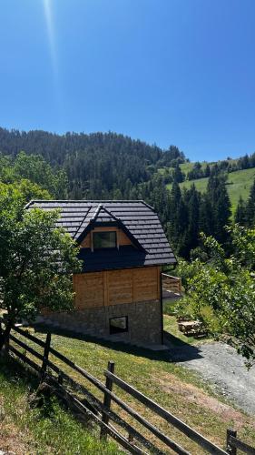 a cabin in the middle of a field with a fence at Planinska koliba Dada in Popovići
