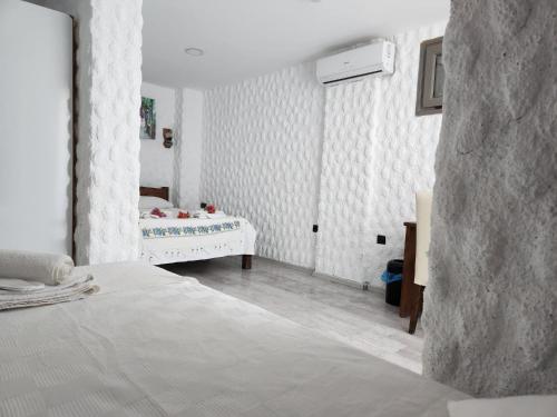 a white room with a bed and a crib in it at rastgeleakkumotel in Seferihisar