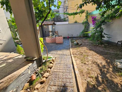 a garden with a brick walkway in a yard at Lemon House in Tirana