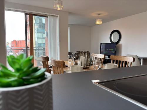 a kitchen and dining room with a table and chairs at LUX 2bed City Centre and AO Arena Free Parking Modern Apt in Manchester