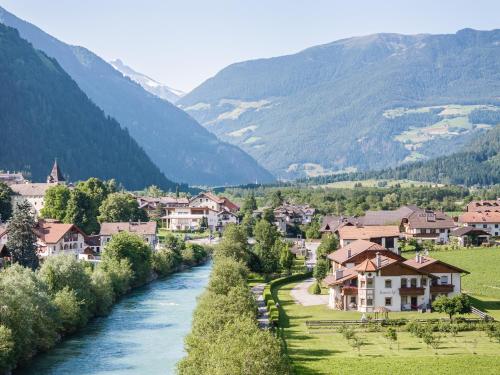 a river flows through a village in the mountains at Anewandterhof in Brunico