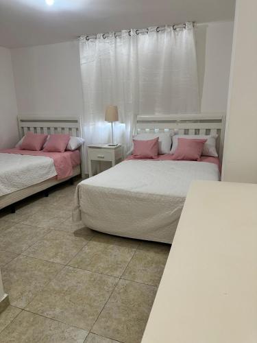 two beds in a room with pink pillows on them at Beachfront Apt With Amazing View at Marbella Juan Dolio in Juan Pedro