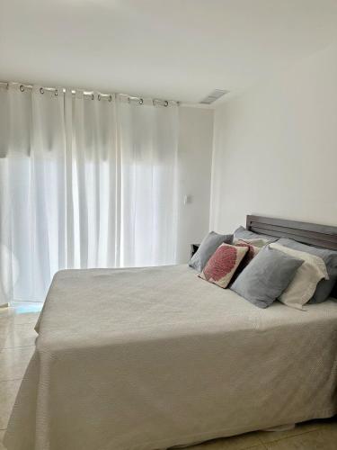 a bedroom with a large bed with white curtains at Beachfront Apt With Amazing View at Marbella Juan Dolio in Juan Pedro