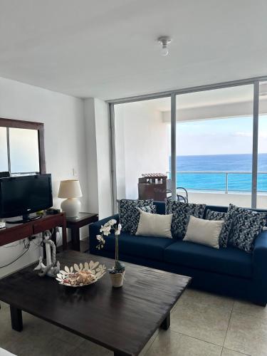 a living room with a blue couch and a table at Beachfront Apt With Amazing View at Marbella Juan Dolio in Juan Pedro