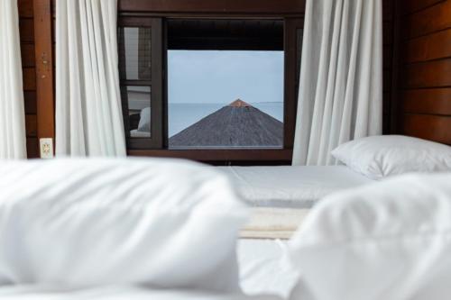 a bedroom with a view of a mountain through a window at Pousada Do Sol Ilha do Mel in Paranaguá