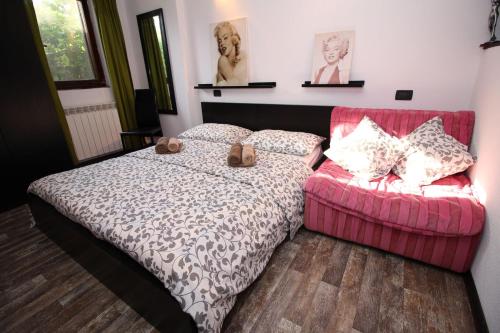 1 dormitorio con 1 cama y 1 sofá rosa en Apartments Nevija, en Rovinj