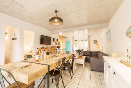 - une cuisine et un salon avec une grande table et des chaises dans l'établissement Maison Biscarrosse Bourg,6 personnes avec grande terrasse Classé 1 étoile, à Biscarrosse