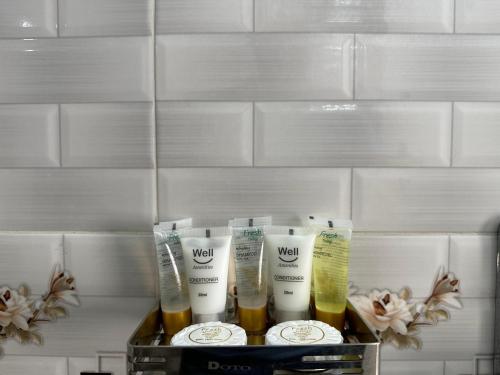 a shelf with four bottles of hair products on it at The Ambassador Hotel Dhanmondi in Dhaka