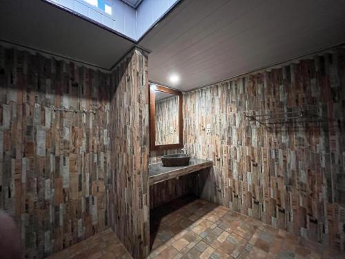 a bathroom with a stone wall with a sink at Coral Beach Seaside in Gili Trawangan