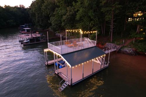 Un barco con luces en el agua. en Lake Lanier Lodge - Dock Views & Fire Pit, en Cumming