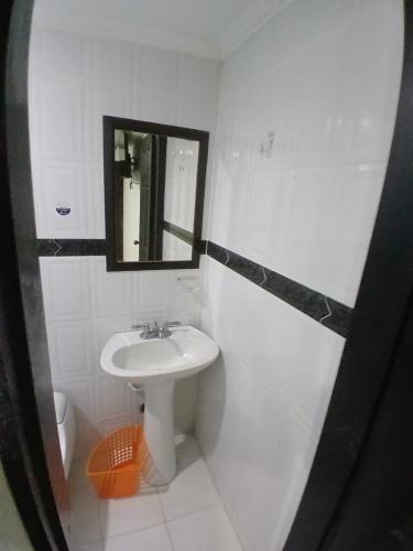 a white bathroom with a sink and a mirror at Hotel Plaza Norte Cali in Cali