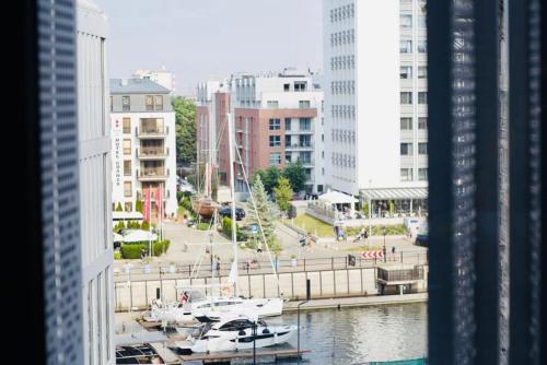 a view of a harbor with boats in a city at Deluxe Apartment on Granary Island with Parking - Granaria I & by Noclegi Renters in Gdańsk