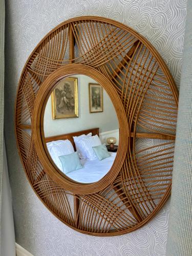 a circular mirror in a room with a bed at Manoir de Daubeuf in Daubeuf-Serville