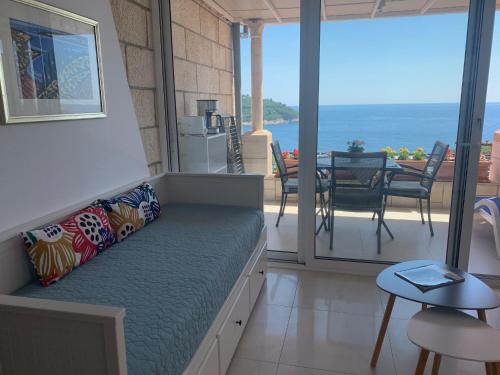 a couch in a room with a view of the ocean at Villa Leoni in Dubrovnik