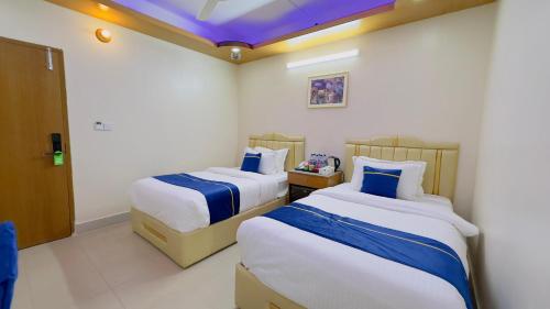 a bedroom with two beds and a purple ceiling at The Ambassador Hotel Dhanmondi in Dhaka