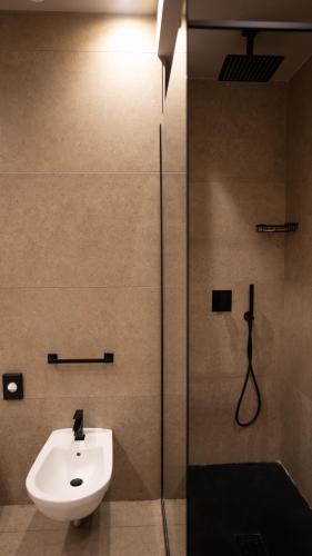 a bathroom with a shower and a sink and a toilet at Altafiumara Resort & Spa in Villa San Giovanni