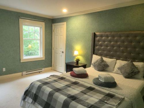 a bedroom with a bed with a plaid blanket and a window at Kerrisdale cozy house in Vancouver