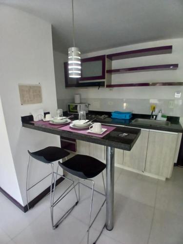 a kitchen with a table and two bar stools at Hotel Plaza Norte Cali in Cali