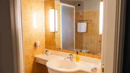 a bathroom with a sink and a mirror at Altafiumara Resort & Spa in Villa San Giovanni
