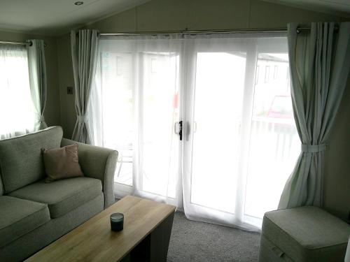 a living room with a couch and a coffee table at Kings Ashington 6 Berth Central Heated Enclosed Veranda in Chapel Saint Leonards