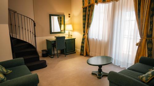 a living room with a staircase and a table at Altafiumara Resort & Spa in Villa San Giovanni