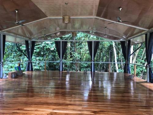 a large room with a wooden floor and trees at Private Cabina at Yoga Center in Ojochal