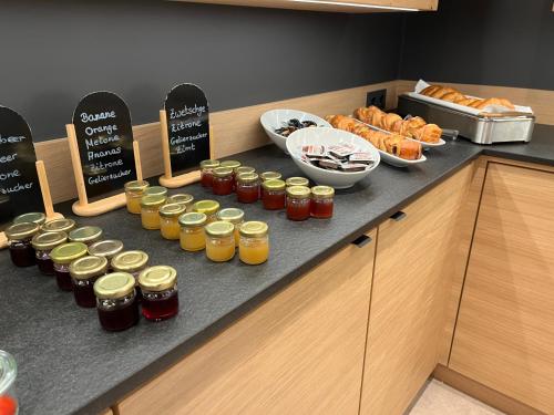 a counter with jars of honey and croissants and bread at Hotel Touric in Korbach