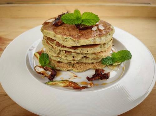 a stack of pancakes on a plate on a table at The Postcard Saligao in Calangute