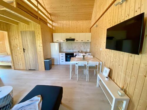 a kitchen and dining room with a table and chairs at Mile domki in Jarosławiec
