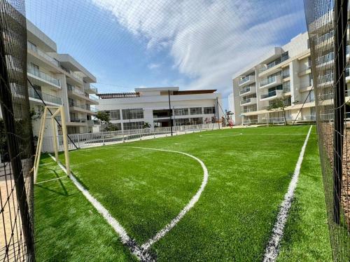an empty soccer field in front of a building at Hermoso apartamento serena del mar #1 in Puerto Tierrabaja