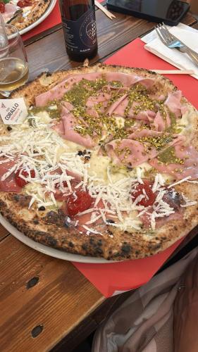 a pizza with ham and cheese on a table at Malù23 B&B Lumezzane in Lumezzane